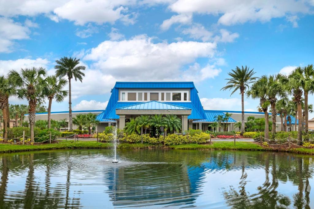 奥兰多Hilton Vacation Club Aqua Sol Orlando West的一座带池塘和棕榈树的房子