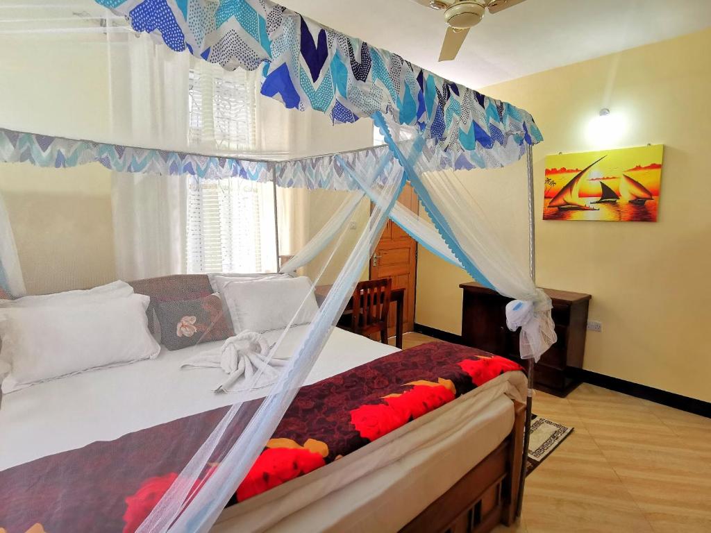 Chaki ChakiSinthia Hotel Apartments的一间卧室配有一张带天蓬的床