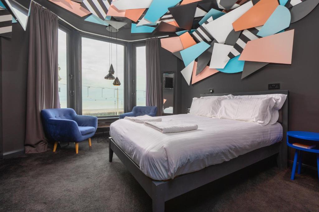 布莱克浦ART B&B的一间卧室配有一张床和两张蓝色椅子