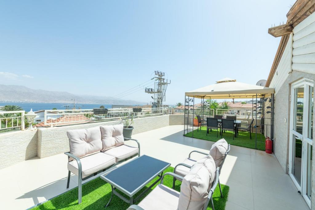 埃拉特Villa Li Eilat的配有白色家具的庭院,享有水景