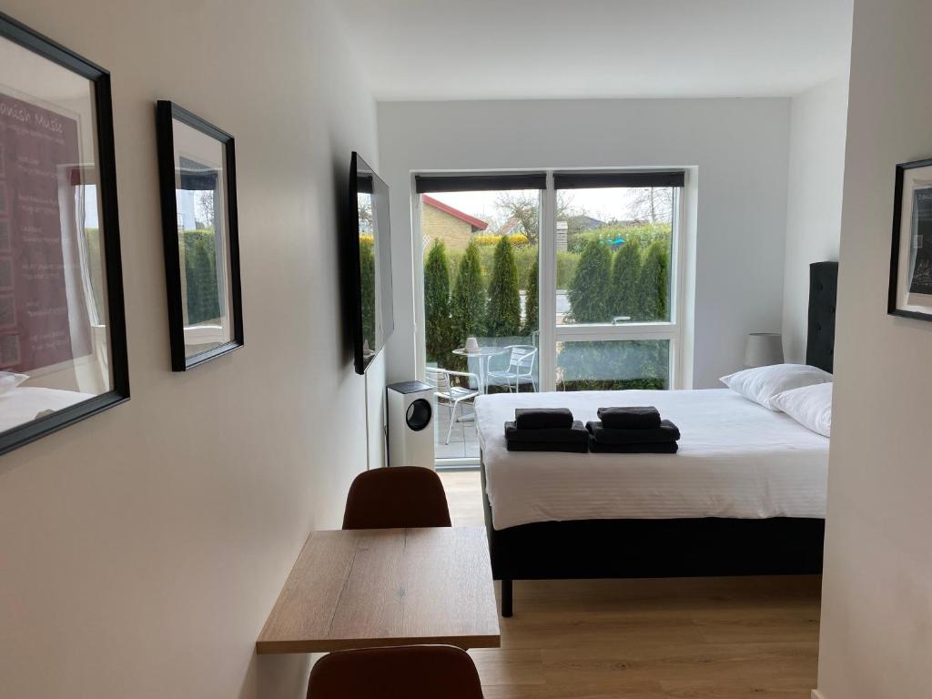 哥本哈根CPH Like Home的一间卧室配有一张床、一张桌子和一个窗户。