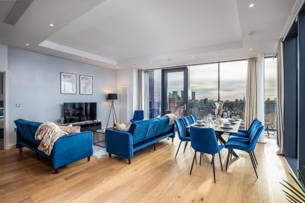 伦敦Luxury & Spacious 2 BR APT with City Views的一间配备有蓝色椅子和一张桌子的景观餐厅