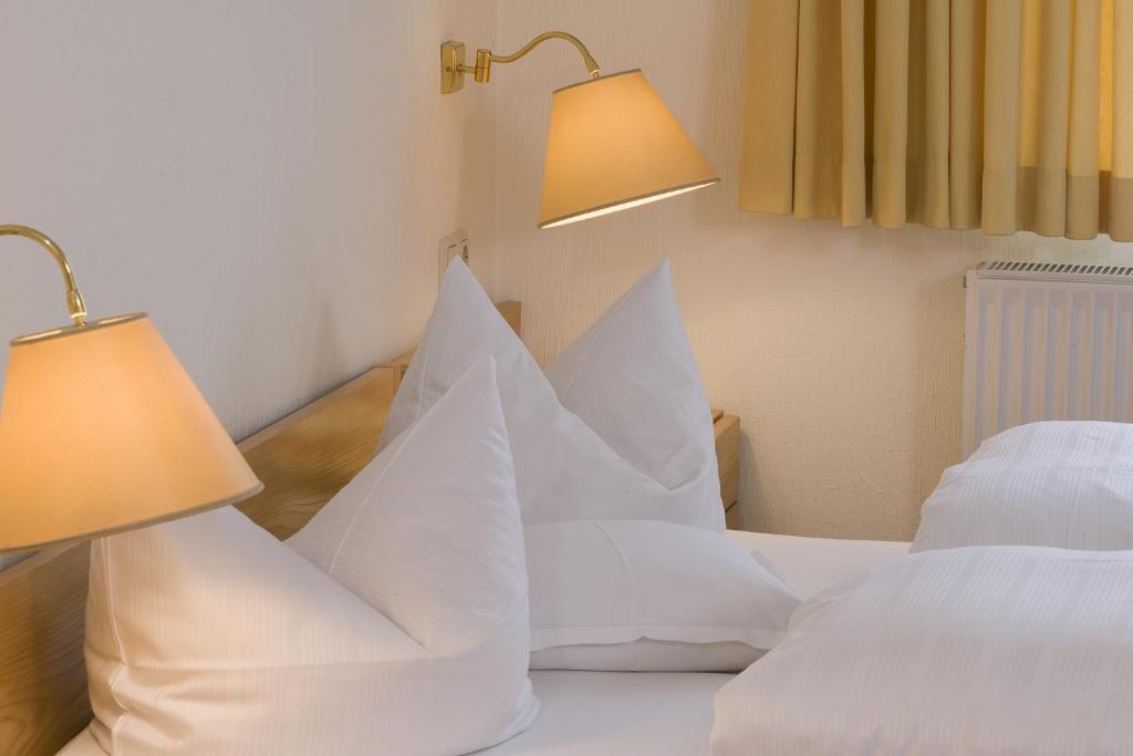 蒂门多弗施特兰德弗里登公园酒店的卧室配有白色枕头和两盏灯。