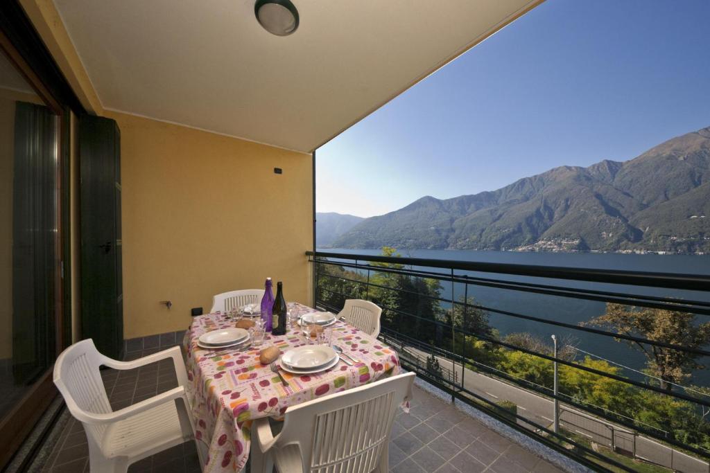 特龙扎诺拉戈马焦雷Va Pensiero sul lago Stunning View的阳台配有桌椅,享有水景