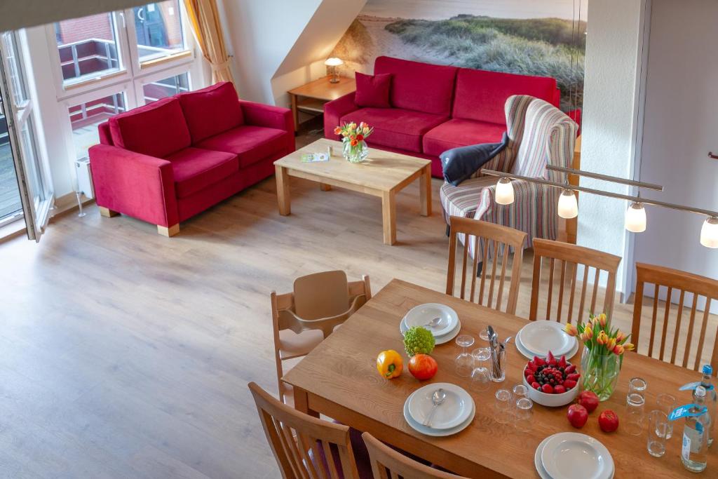 文尼斯塔特Ferienzentrum Wenningstedt的客厅配有红色的沙发和桌子