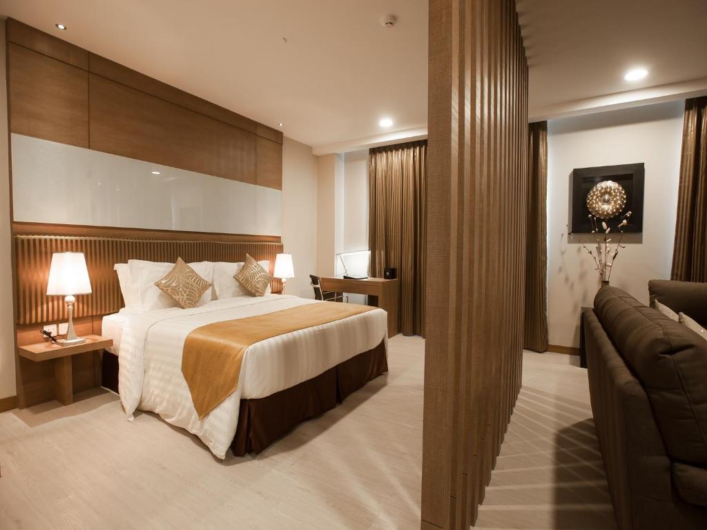 Kuala Belait花园中心酒店的酒店客房,配有床和沙发