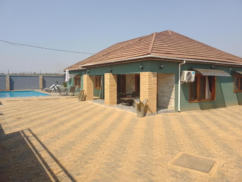 MumbwaALIJAY APARTMENTS的一座带庭院和游泳池的房子