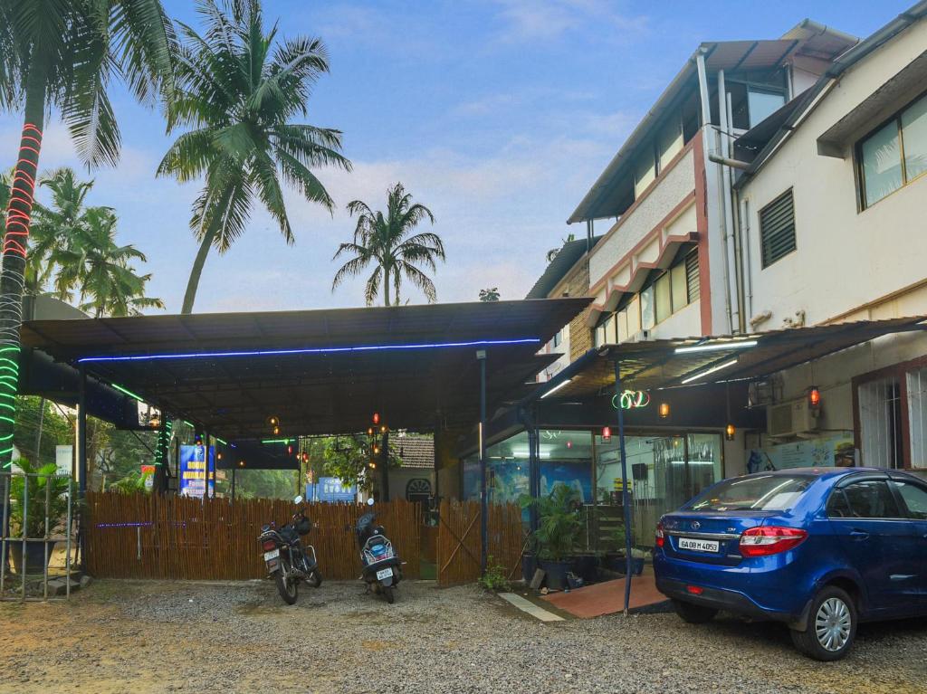 尼禄Collection O Goa Savera Holiday Homes的停在一座带摩托车的建筑前面的汽车