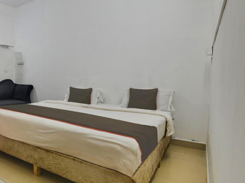 尼禄Collection O Goa Savera Holiday Homes的卧室配有一张带白色墙壁的大床