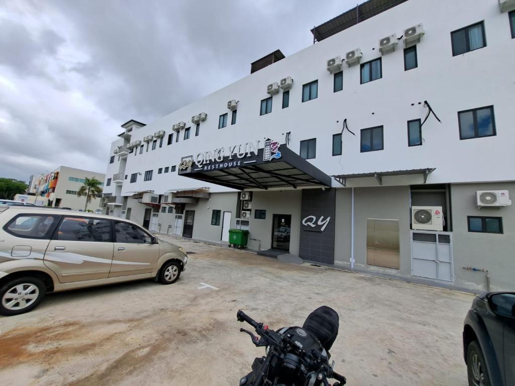 斯里巴加湾市Qing Yun Rest House Koprijaya, Brunei Darussalam的停在大楼前停车场的汽车