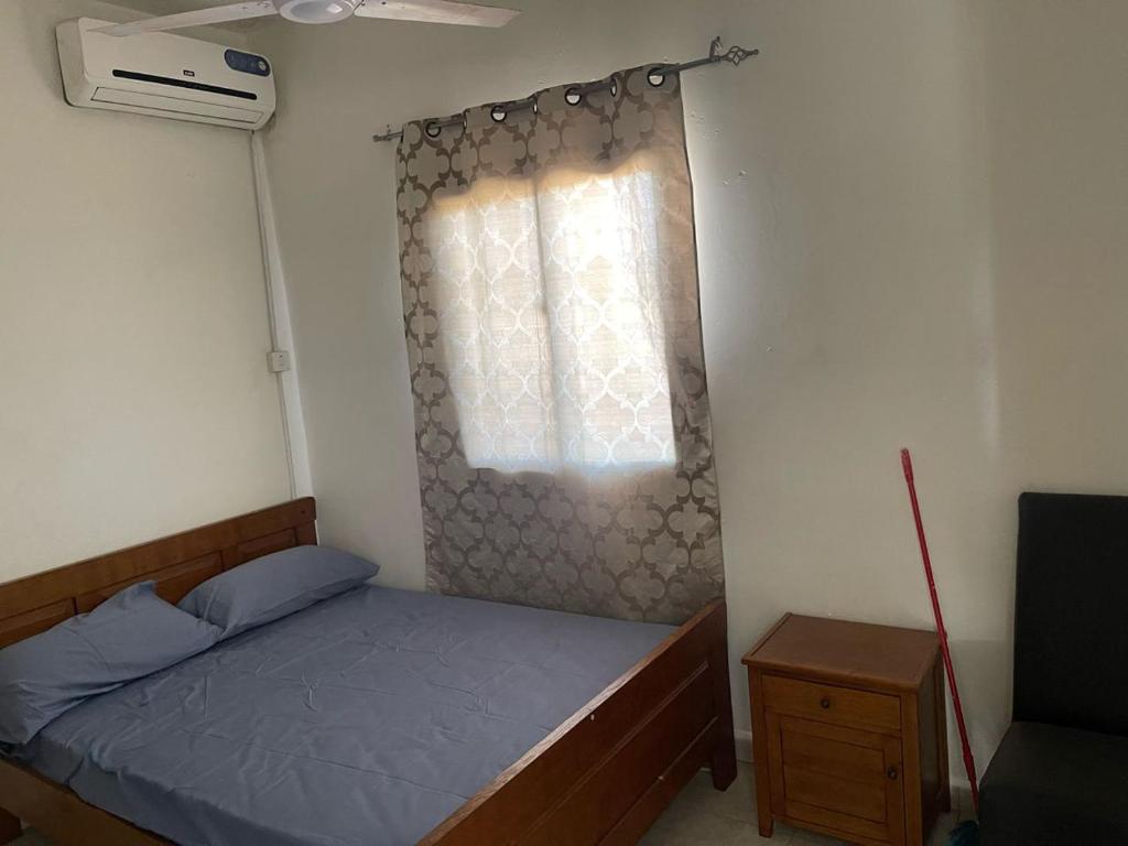 SukutaSamba Tako Plaza Home Suites的一间小卧室,配有床和窗户