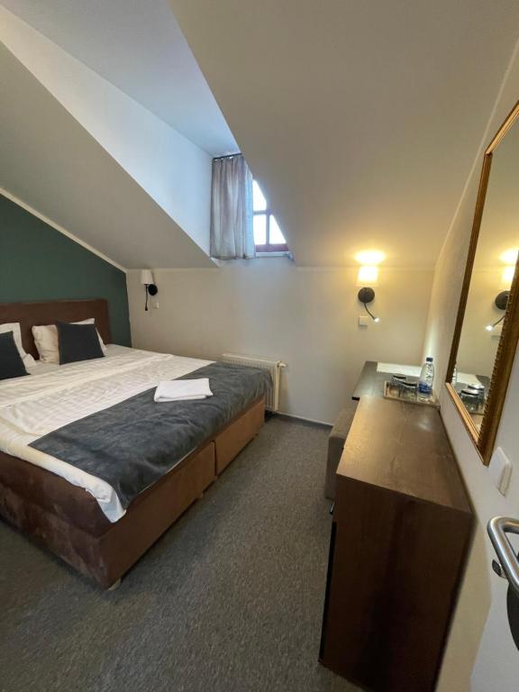 考纳斯苹果经济型酒店的一间卧室配有一张大床和镜子