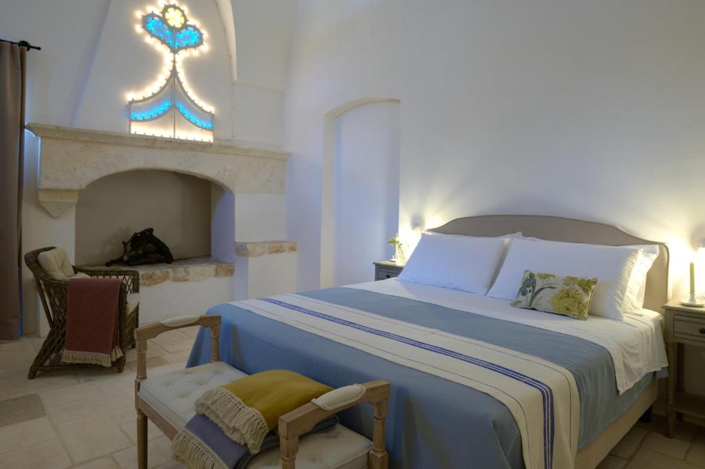 法萨诺Masseria Celeste的一间卧室设有一张大床和一个壁炉