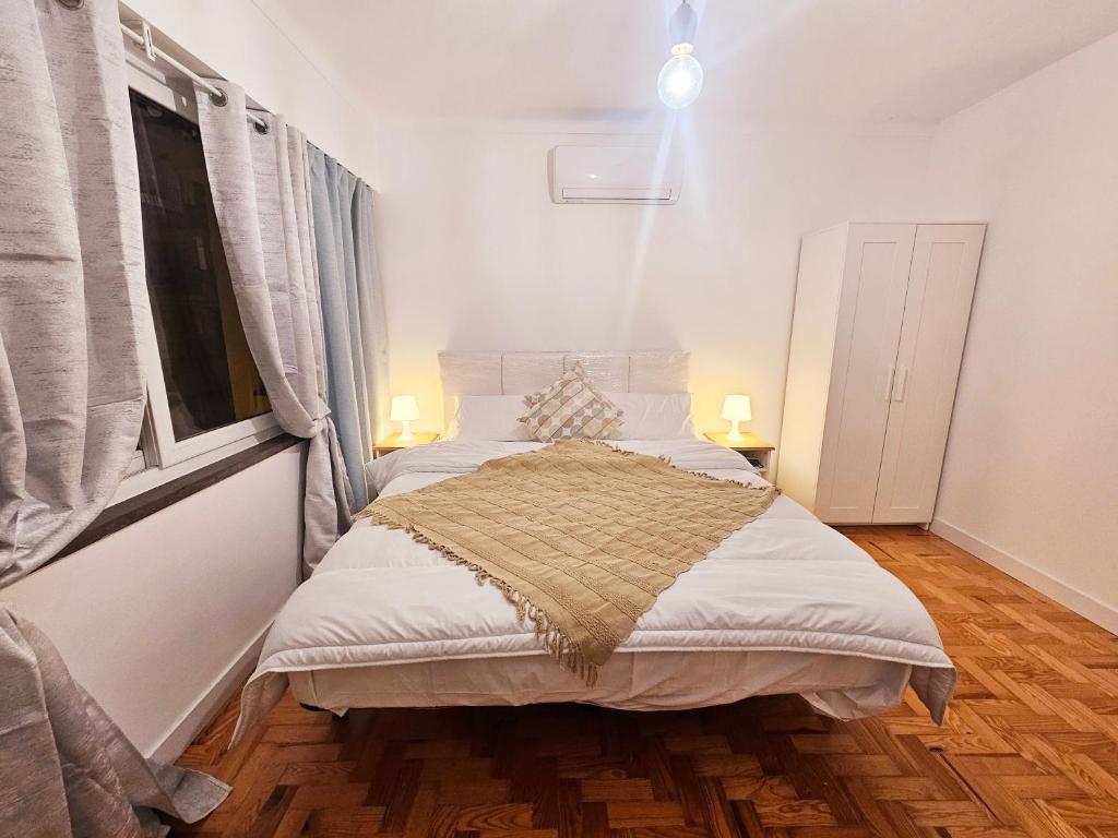 卡斯卡伊斯Peers Guest House的一间卧室配有一张带白色床单的床和一扇窗户。