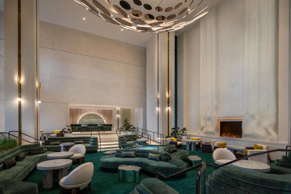 洛杉矶好莱坞W酒店的大堂配有沙发、桌子和壁炉。