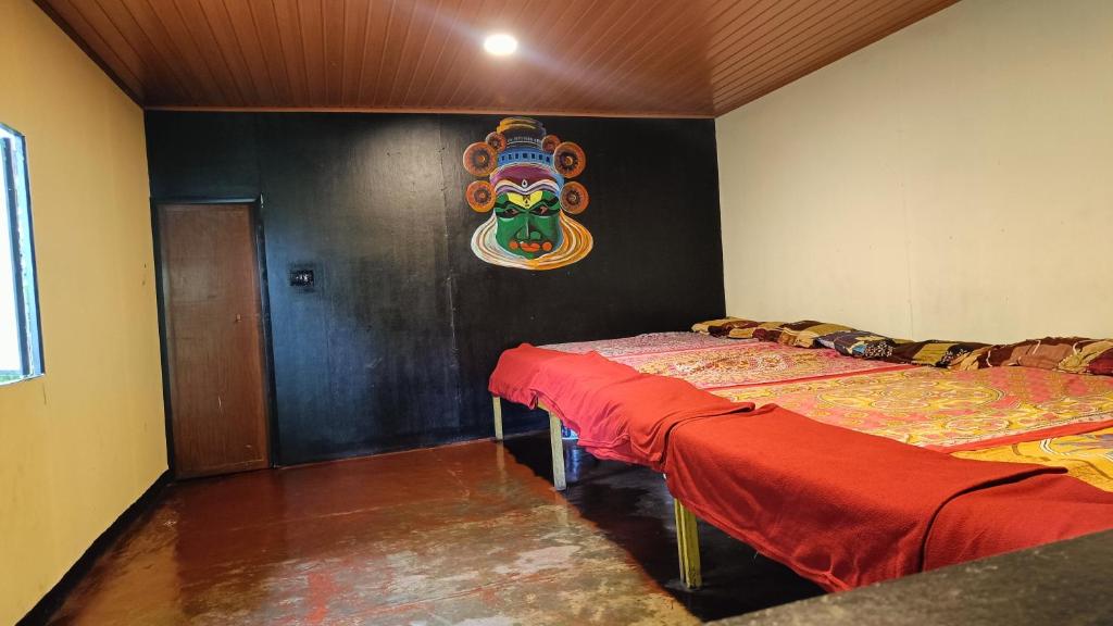 蒙纳Triloka Dorm by The Offbeat Crew的墙上有面具的房间的两张床