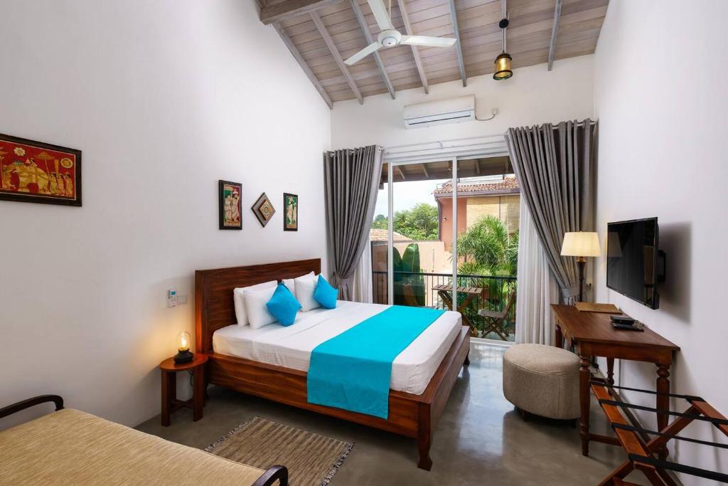 斯里贾亚瓦德纳普拉科特Angam Suites Colombo的一间卧室配有一张床、一张书桌和一个窗户。