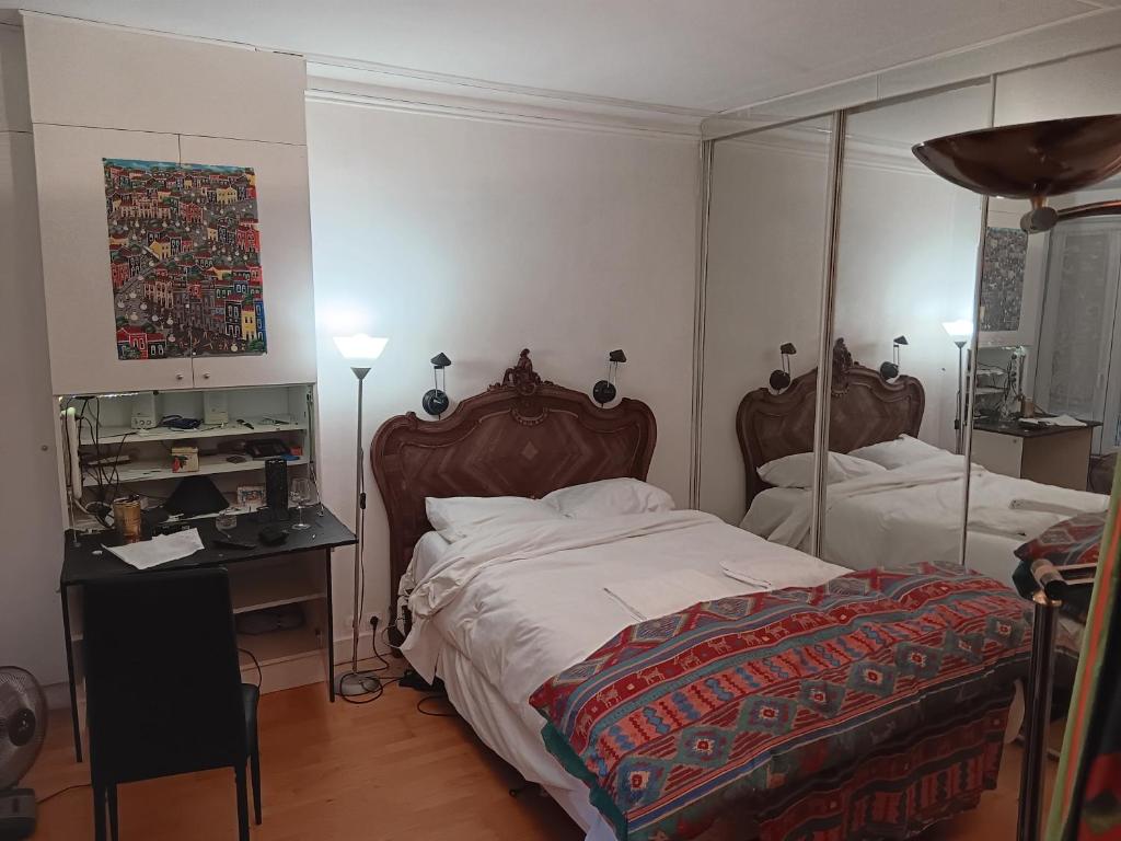 巴黎Apart calmo em paris jourdain的一间卧室配有两张床、一张桌子和一面镜子