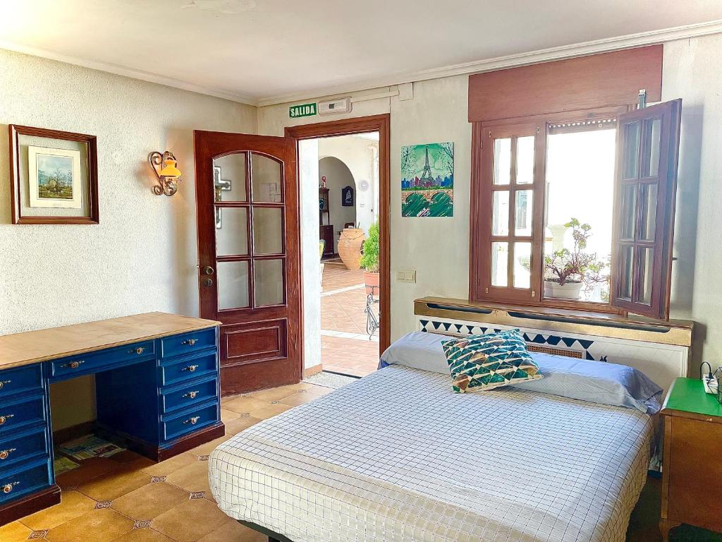 巴尔铁拉Casa Rural Ángel的一间卧室配有一张床、一张书桌和一个窗户。