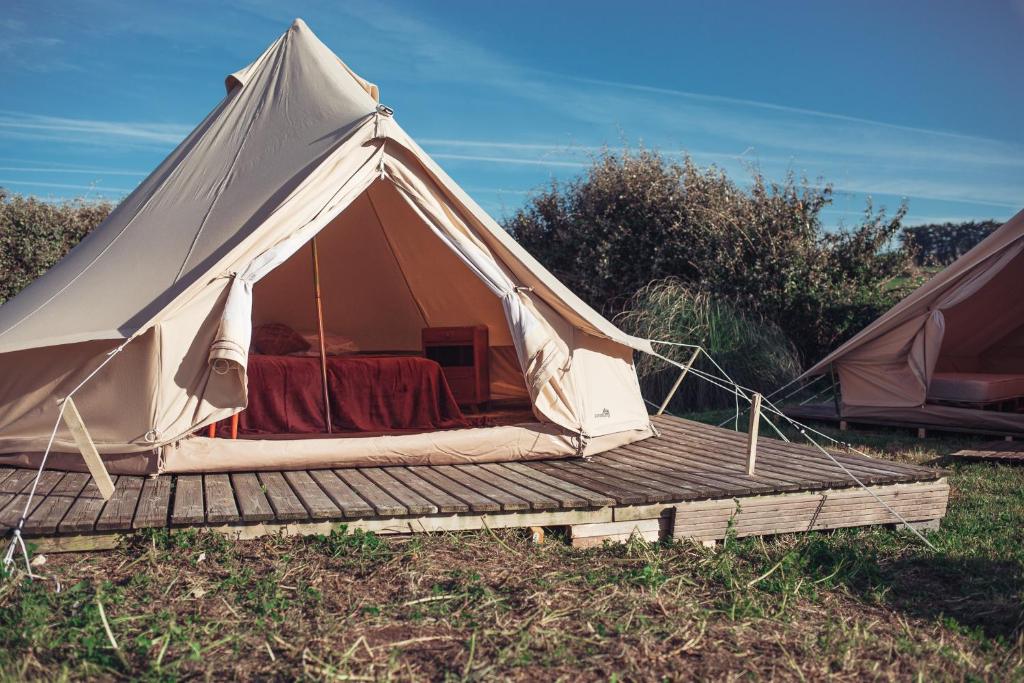 坡隆维茨普尔扎伊The Glamping Spot - Douarnenez的帆布帐篷,在田野上设有木甲板
