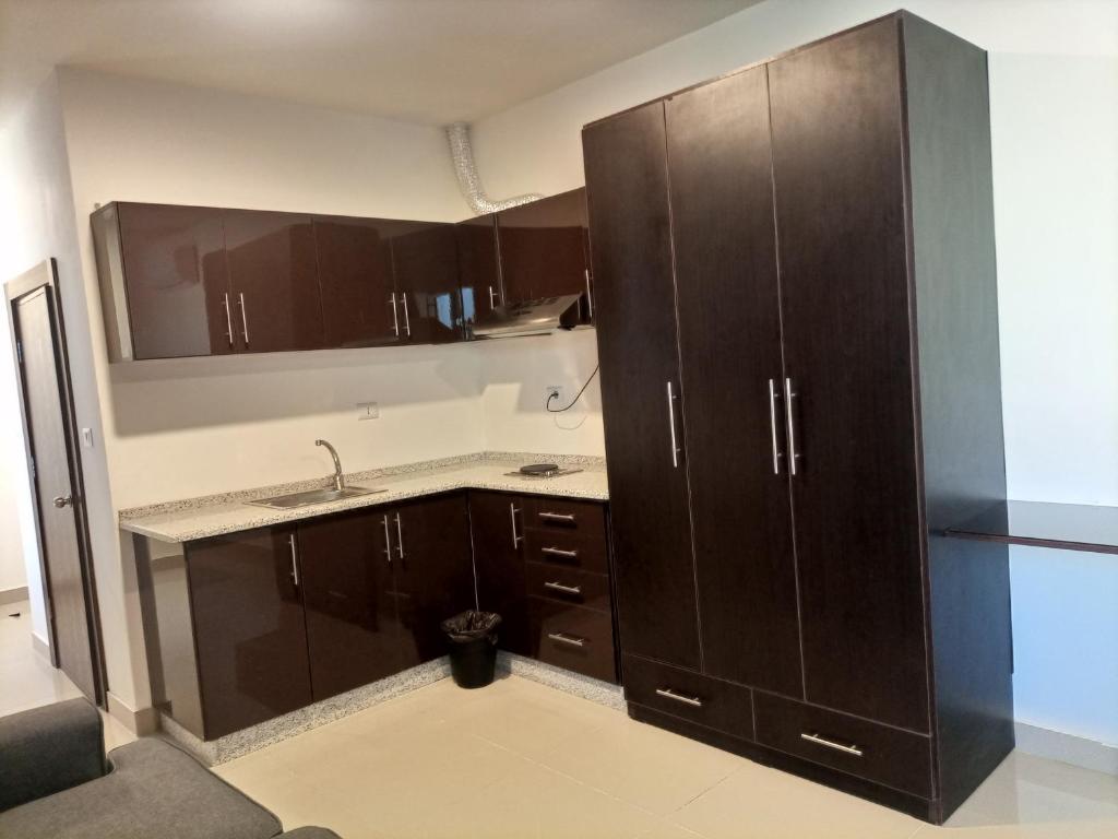 安曼Monument Suites的厨房配有棕色橱柜和水槽