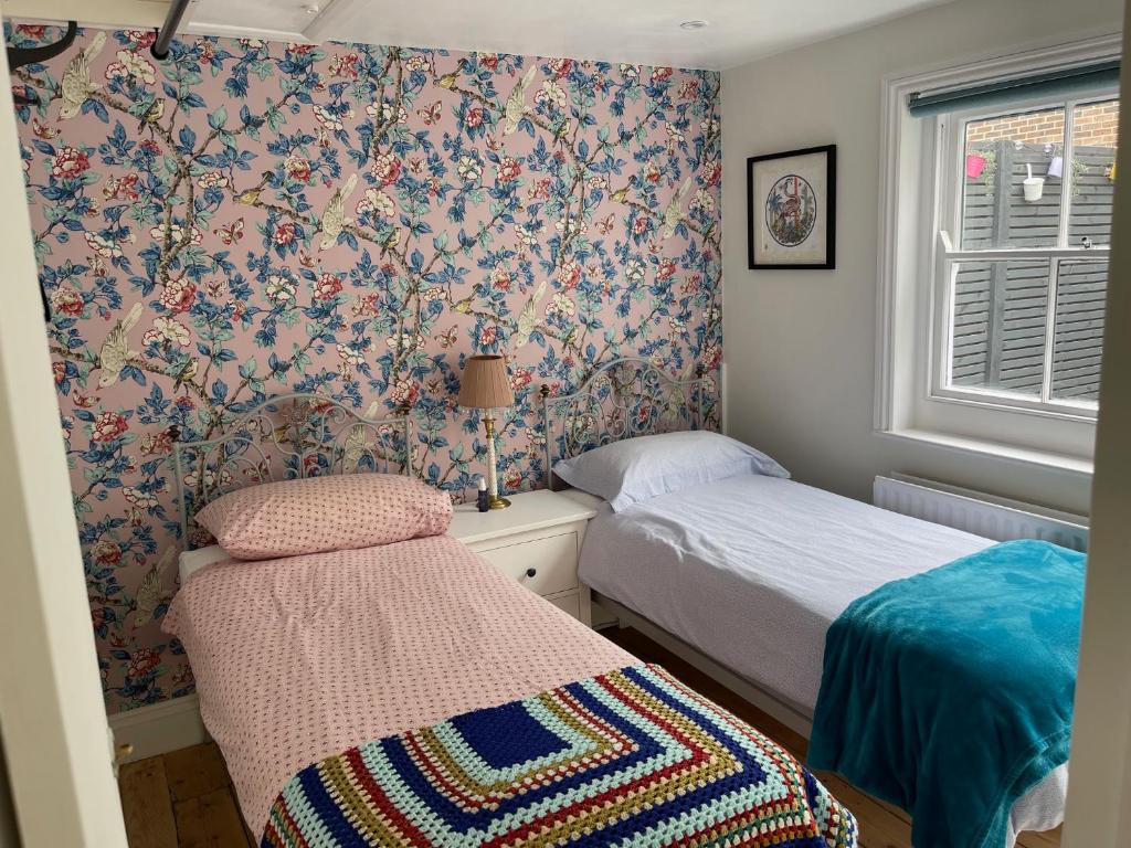 布莱顿霍夫North Laine Sunny Cottage的一间小卧室,配有两张床和窗户