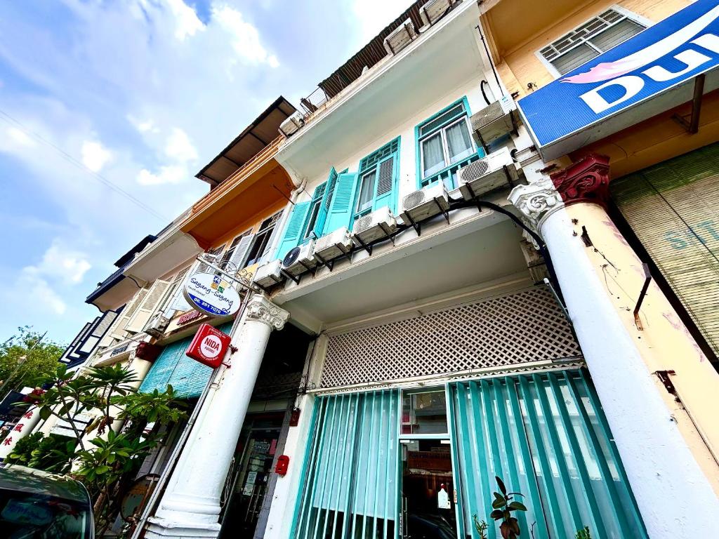 马六甲Melaka jonker street kids friendly guesthouse Malacca的一座建筑,上面有蓝色的门和标志