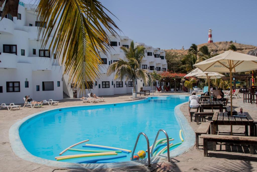 曼克拉Loki del Mar的酒店旁的游泳池配有椅子和遮阳伞