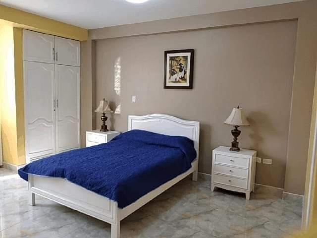 特鲁希略HOSPEDAJE VALERY的一间卧室配有蓝色的床和2个床头柜