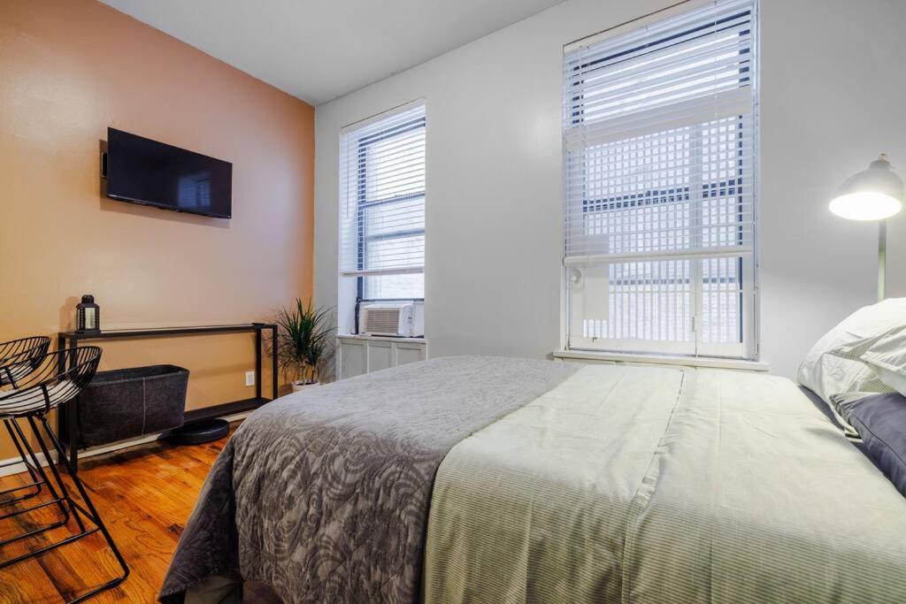 纽约Park Side Living, Get Cozy的一间卧室配有一张床和一台平面电视
