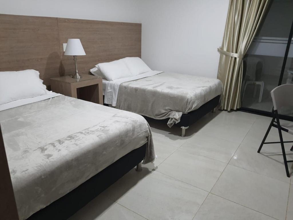 帕尔米拉Hotel Melao的酒店客房,配有两张床和椅子