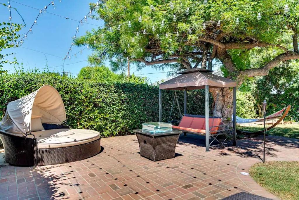 洛杉矶House In Lake Balboa/Los Angeles的庭院配有椅子、遮阳伞和吊床。