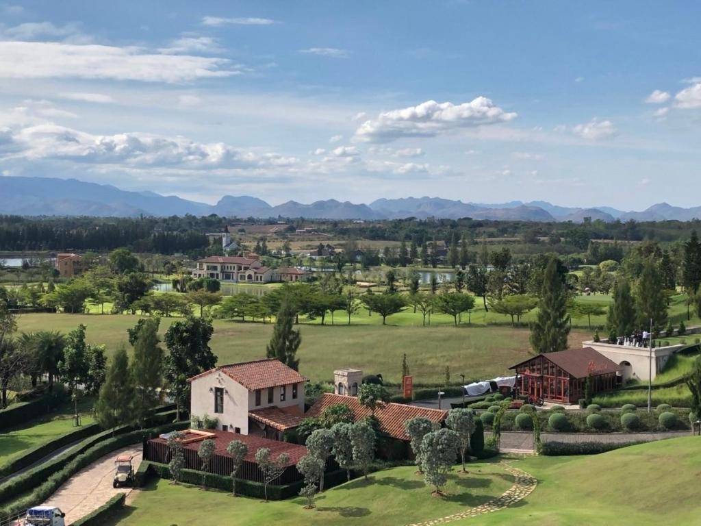 北冲Toscana Villa Khao Yai的绿色田野中房屋的空中景观