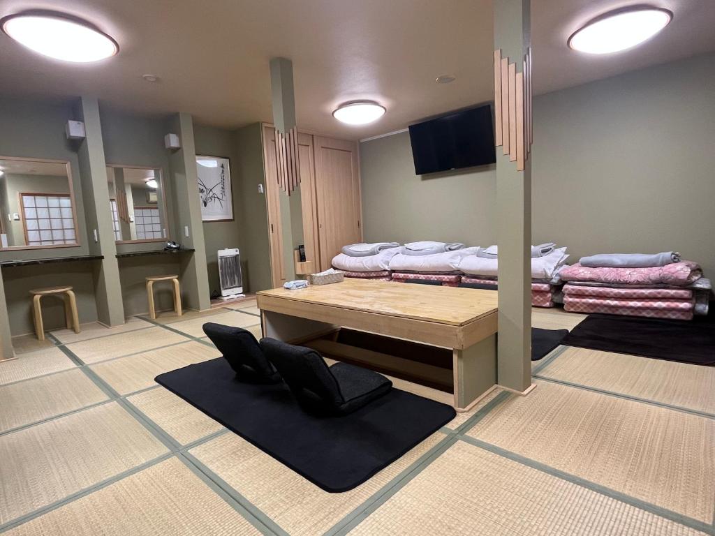 大阪Wafu Ryokan Uehonmachi的一间设有一张桌子和一组床铺的房间