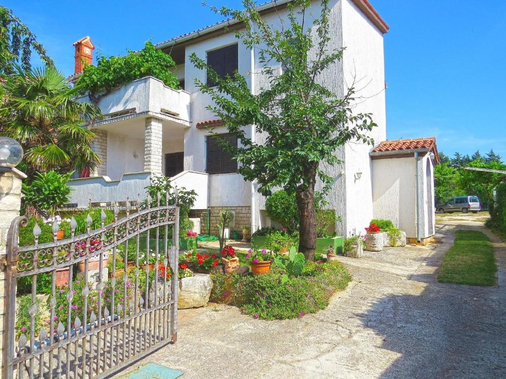 梅杜林Ferienwohnung für 2 Personen ca 28 qm in Medulin, Istrien Südküste von Istrien的白色的房子,有栅栏和鲜花