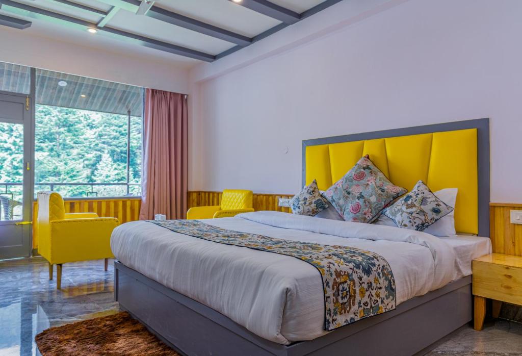 马拉里Hotel Apple Flower, by Manali Mall Road Resorts, Near Hadimba Temple的一间卧室配有一张带黄色床头板的大床