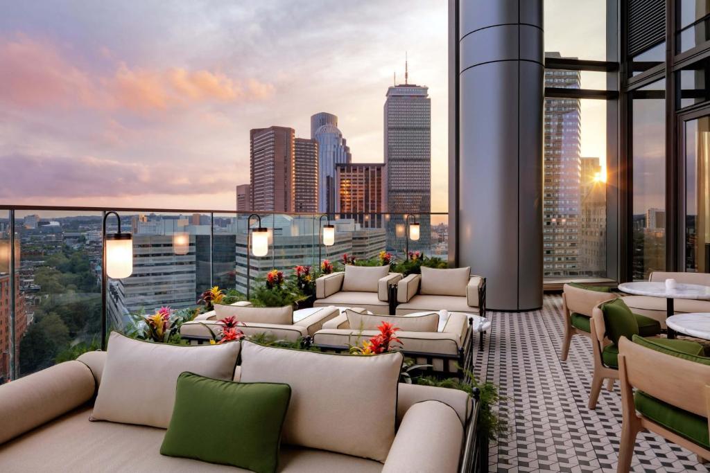 波士顿Boston West End Penthouse Edition的屋顶庭院设有沙发和桌子,享有城市天际线