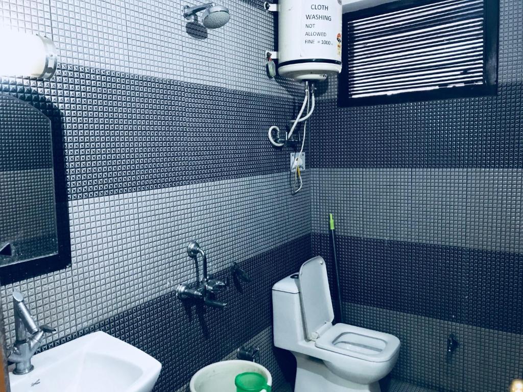 钱德加尔DevDham Lodge的一间带卫生间和水槽的小浴室