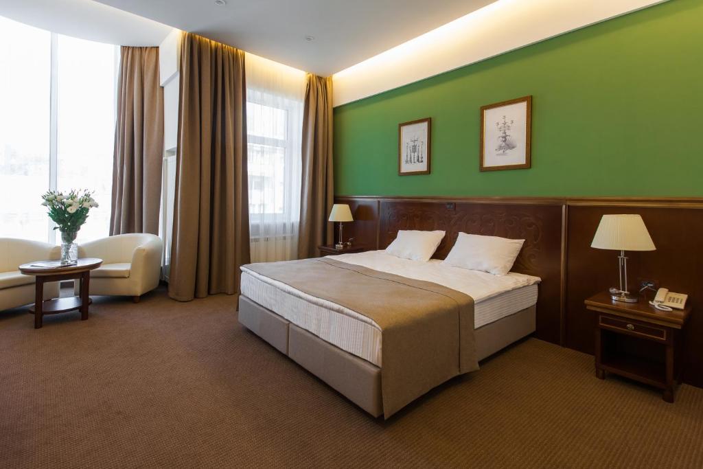 敖德萨Alarus Luxe Hotel的酒店客房,设有床铺和绿色的墙壁