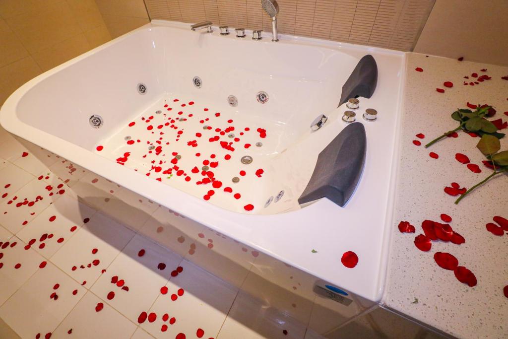 欧奈宰Cheerful Al Waha Hotel Unayzah - فندق شيرفل عنيزة的地板上装满红色鲜花的浴缸