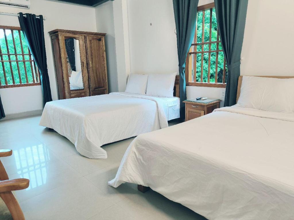 吉婆岛Full Day Boat Trip to Discover Lan Ha Bay & And Stay Hotel Catba的一间卧室设有两张床和两个窗户。
