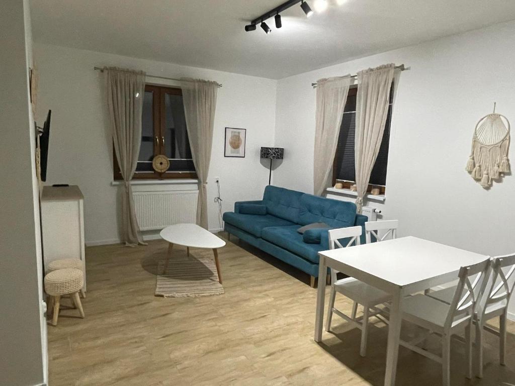 米科瓦伊基Apartamenty Mazury的客厅配有蓝色的沙发和桌子