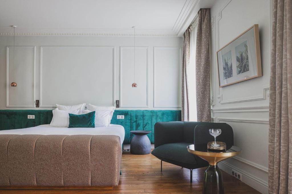 波尔多Hôtel Singulier Bordeaux的配有一张床和一把椅子的酒店客房