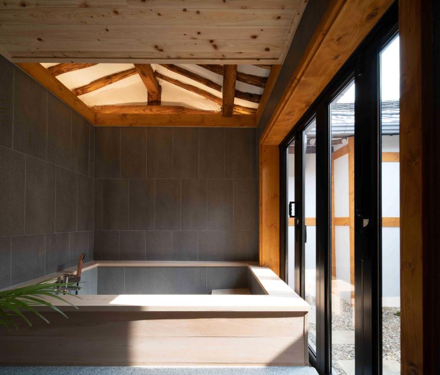 首尔Luxury hanok with private bathtub - SW02的浴缸位于带窗户的客房中间