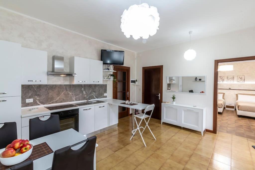 斯嘉德瓦利La Casara appartamento Eligia的厨房配有白色橱柜和一张带一碗水果的桌子