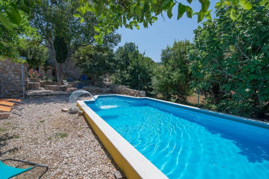 大洛希尼Ferienhaus mit Privatpool für 4 Personen ca 70 qm in Veli Lošinj, Kvarner Bucht Losinj的庭院里的一个蓝色海水游泳池