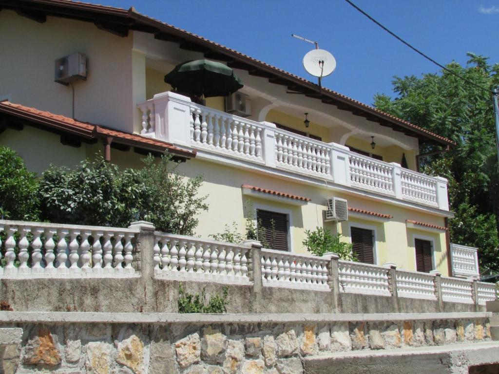 奥帕提亚Guesthouse Katarina的墙上有白色阳台的房子