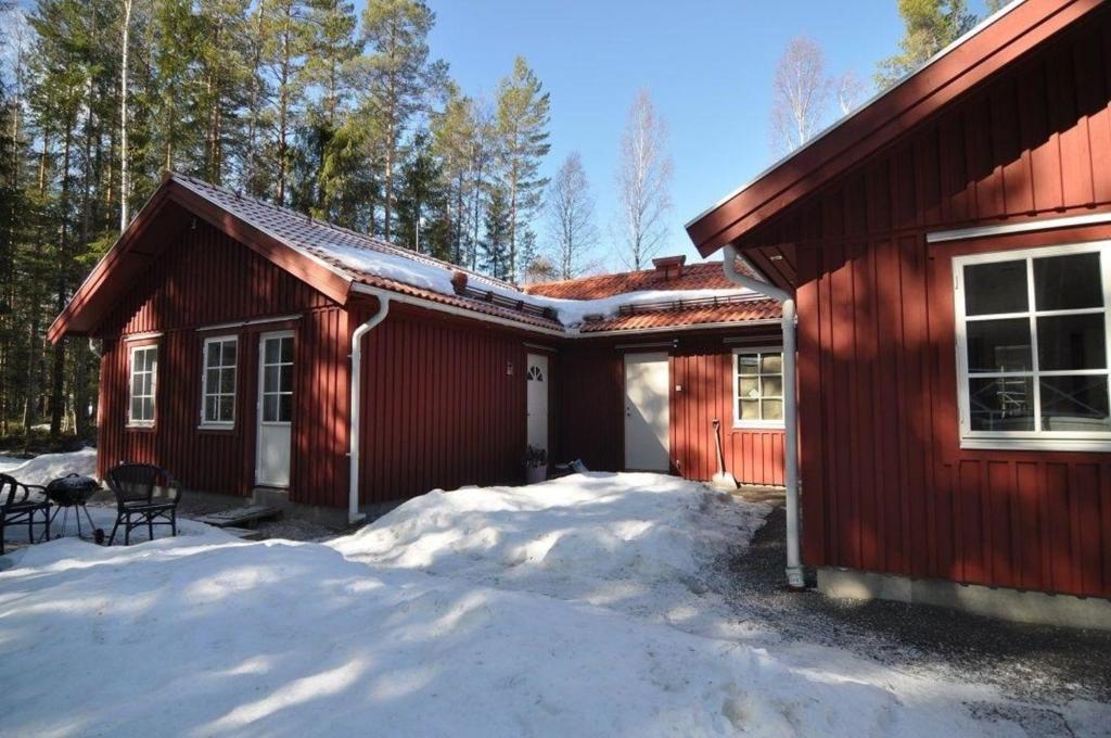 博伦厄Ferienwohnung für 5 Personen ca 60 qm in Borlänge, Mittelschweden See Runn的前面有雪的红色房子