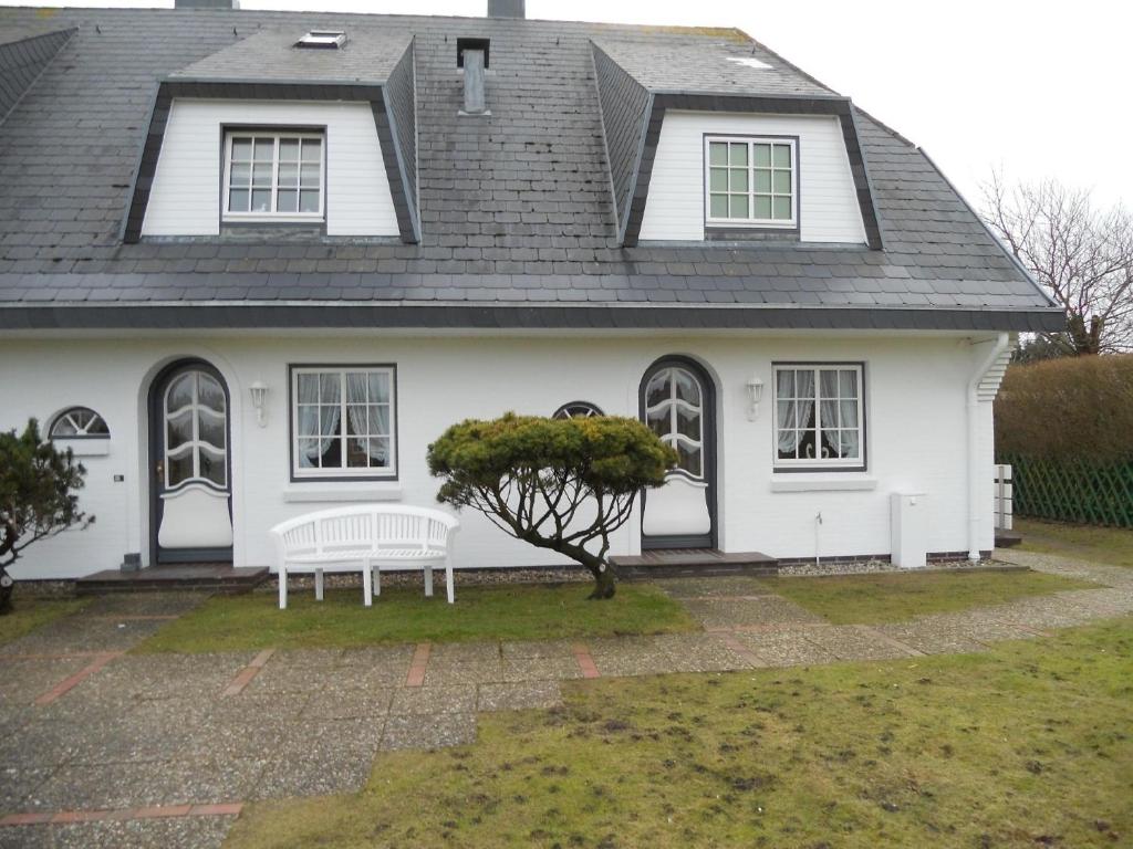 曼克玛肖Ferienwohnung für 2 Personen ca 55 qm in Munkmarsch, Nordfriesische Inseln Sylt - a87454的前面有长凳的白色房子