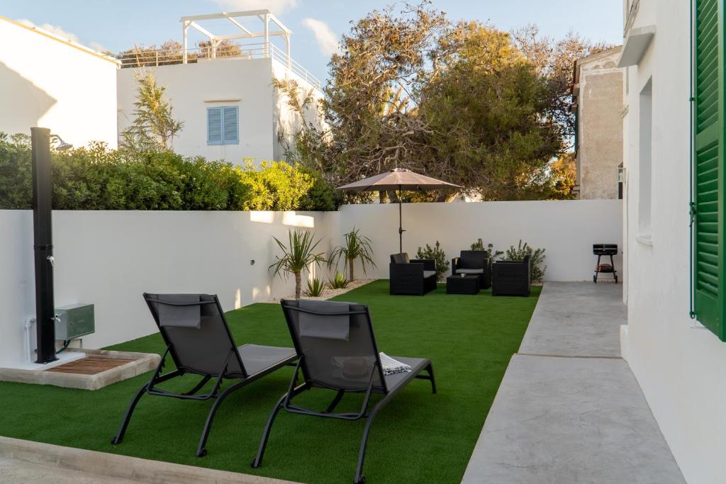 桑坦德利亚湾Apartamento Villa Irene Menorca的一个带椅子的花园和一个草坪